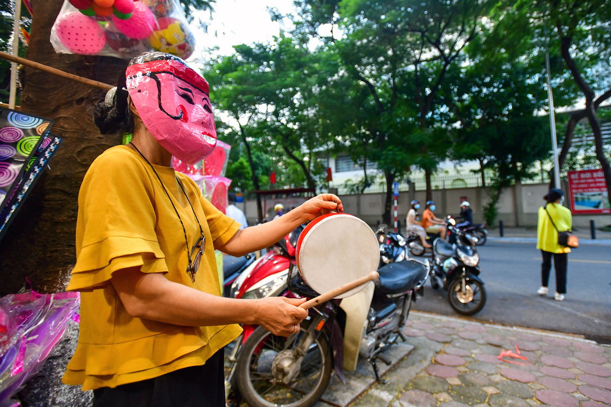 Chị Đặng Thị Lược (53 tuổi), chủ một cửa hàng văn phòng phẩm, hóa trang thành ông địa gõ trống để gây sự chú ý với khách hàng. Hình ảnh này vốn xuất hiện ở chợ Trung thu phố cổ Hàng Mã, Hàng Lược những năm trước khi chưa có đại dịch.