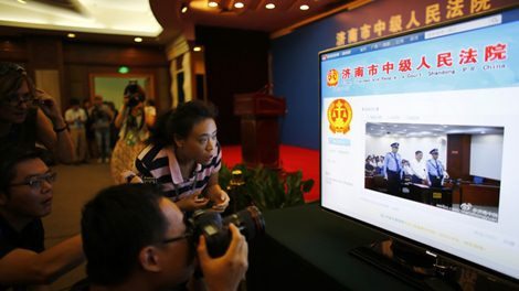 Phóng viên, nhà báo theo dõi vụ xét xử ông Bạc Hy Lai trên màn hình TV hiển thị trang microblog của tòa án Tế Nam ở Sina Weibo.