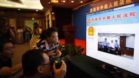 Phóng viên, nhà báo theo dõi vụ xét xử ông Bạc Hy Lai trên màn hình TV hiển thị trang microblog của tòa án Tế Nam ở Sina Weibo.