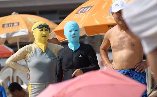 Chống nắng bằng mặt nạ cao su. Tại tỉnh Sơn Đông, Trung Quốc, 1 loại đồ bơi chống nắng đặc biệt đã được phái đẹp nơi đây sử dụng rất rộng rãi trên khắp bải biễn. Đó là những chiếc áo bơi được thiết thế kín mít từ cổ tới chân như...áo lặn để che nắng hoàn toàn, chống đen da.