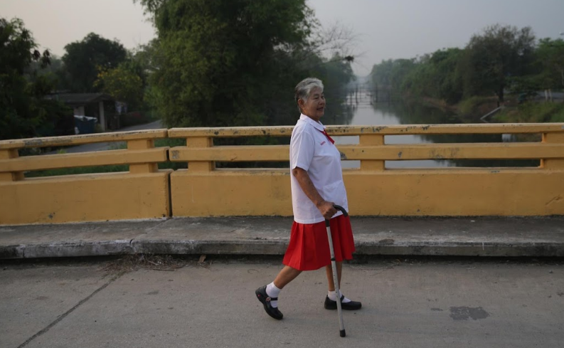 Somjit đi bộ tới bên xe buýt của trường học.