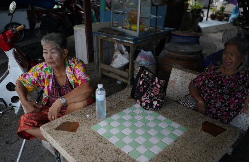 Cụ bà Somjit (trái) và Poonsri Seangnueal (63 tuổi) ngồi trò chuyện với nhau tại mộtcửa hàng ở Thái Lan.