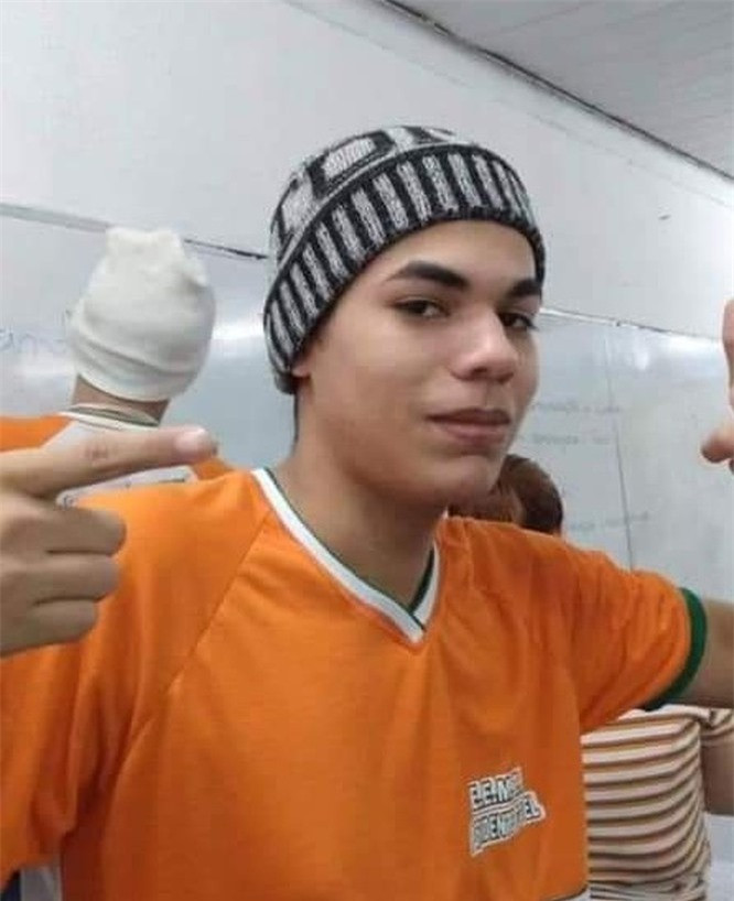 16. Chàng trai này đang cầm cây kem bằng cách nào? 