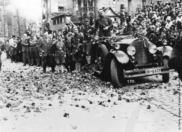 ##sc### Chiếc xe của Adolf Hitler đi qua con đường trải đầy hoa sau khi diễn ra một cuộc mít tinh ở Nuremberg. 