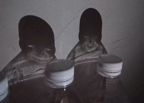 Bóng chai nước in lên bức tường trông như những gương mặt ma quái. 