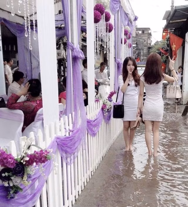 Hai cô nàng xinh đẹp tạo dáng nhí nhảnh trong đám cưới ngày mưa.