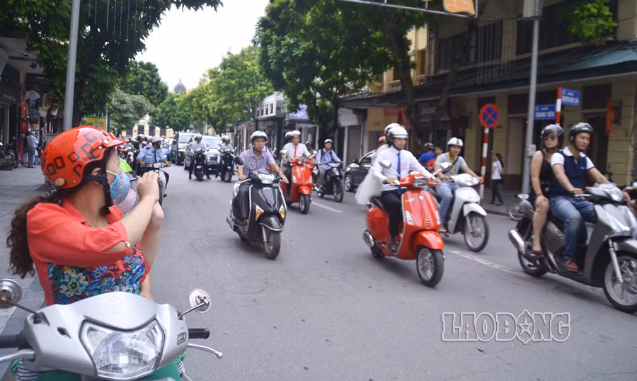 Người dân hai bên đường tranh thủ ghi lại khoảnh khắc khi đoàn cô dâu - chú rể đi qua.