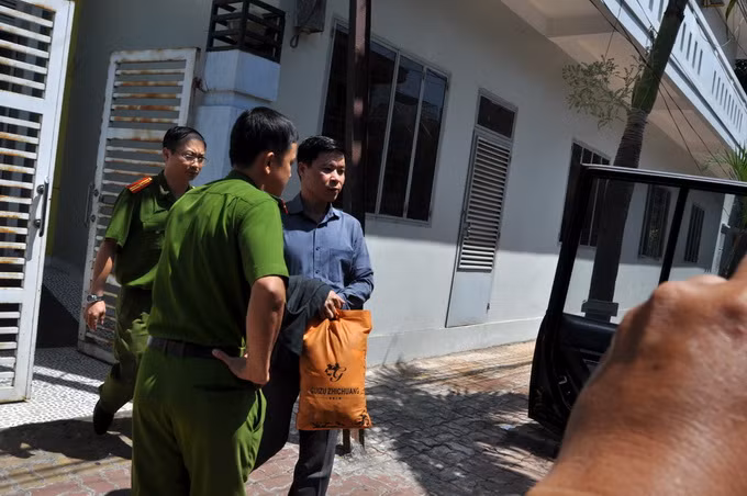 Ông Vũ Quốc Tuấn từ nhà riêng bước lên xe của công an - Ảnh: Đông Hà.