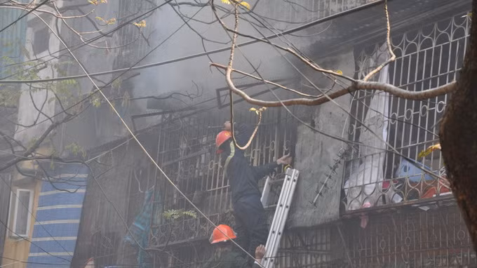 Nhận được thông tin, lực lượng PCCC Công an Hà Nội đã điều động đến hiện trường 4 xe cứu hỏa và hàng chục chiến sĩ chữa cháy đến tham gia dập lửa. Trong ảnh, lực lượng cứu hỏa phải phá hàng rào phía sau để tiếp cận đám cháy.