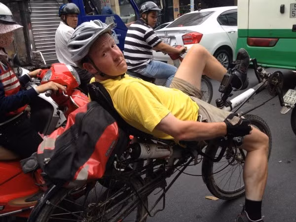 Một cua rơ người nước ngoài đạp xe nằm trên đường phố Sài Gòn.
