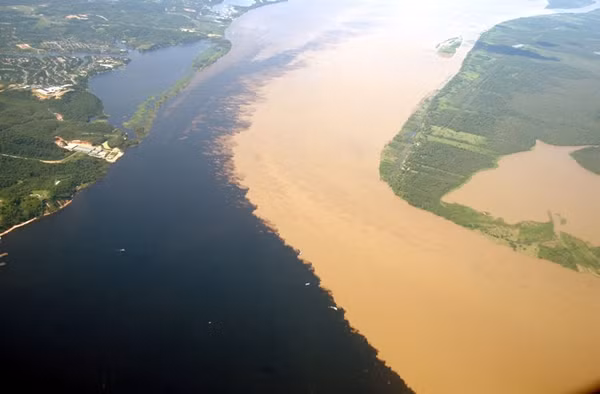 5. Sông Rio Negro và sông Rio Solimoes - Brazil. Sông Rio Negro có nước màu đen còn sông Rio Solimoes mang nặng cát, phù sa nên có màu vàng, khi hai con sông này gặp nhau đã tạo ra hai mảng màu đối lập đặc biệt trên cùng một khu vực. Khung cảnh đặc biệt này kéo dài 6km và là một trong những điểm hấp dẫn khách du lịch bậc nhất ở vùng Manaus, Brazil.
