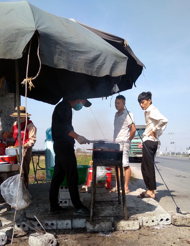 Mo quan com di dong tren xe tai, vo chong tre bam quoc lo kiem song