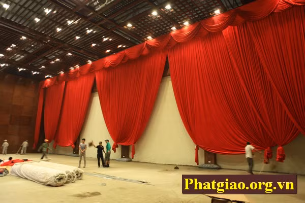 Phía trên khán đài là phần trang trí cũng đang được hàng chục công nhân lau dọn và căn chỉnh phông bạt...