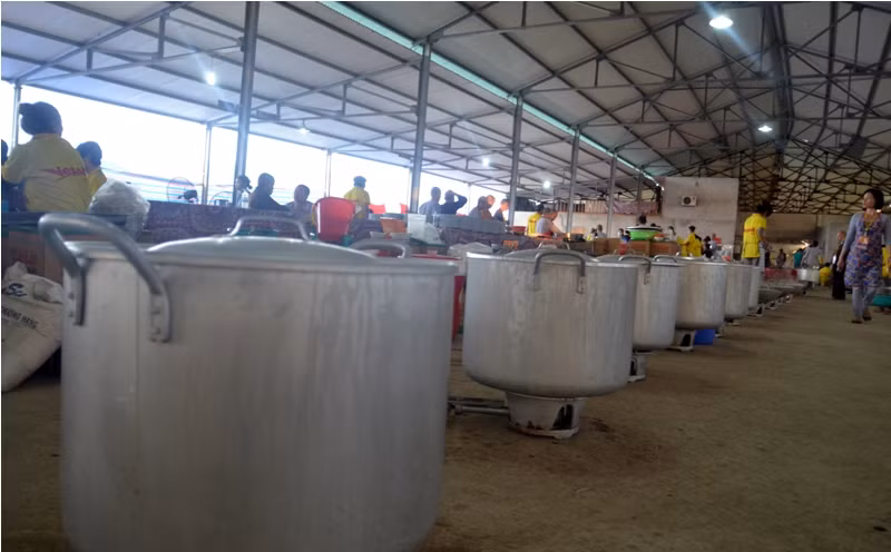 Hàng chục chiếc nồi lớn được đặt thành dãy.