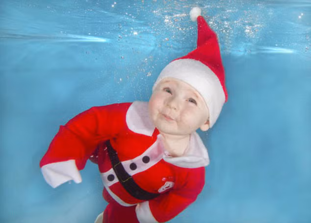 Ông già Noel đùa nghịch với bong bóng trong làn nước trong suốt.