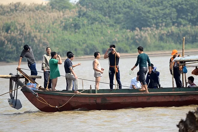 Các thầy giáo và sinh viên khoa Lặn trường Giao thông vận tải tham gia tìm kiếm xác chị Huyền. Ảnh: Theo GĐXH