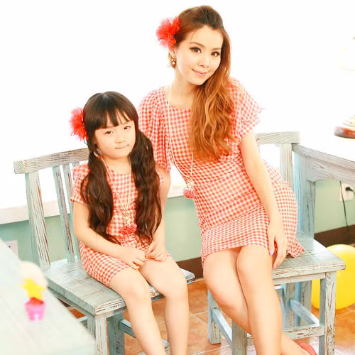 Style váy suông kẻ caro nhẹ nhàng, nhấn nhá thêm chút bèo điệu đà ở cánh tay là sự kết hợp ăn ý cho mẹ và con.