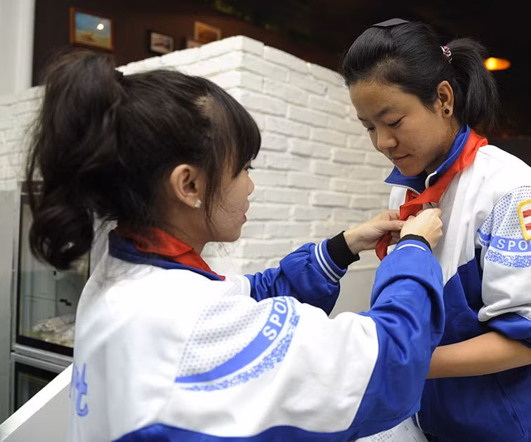 Những cô phục vụ phụ giúp đeo khăn quàng đỏ cho nhau trong nhà hàng ăn mang phong cách độc đáo này.