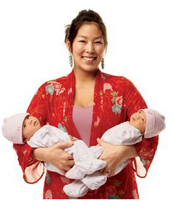 Một cặp song sinh vừa mới chào đời trong vòng tay người mẹ.