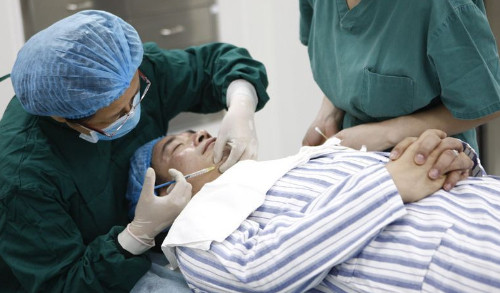 Các bác sĩ đang thực hiện tiêm chất làm đầy, khiến cho da mặt nhạc sĩ này trở nên căng bóng như thời xuân trẻ.