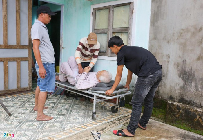 Người thân và lực lượng chức năng phải sử dụng xe để đưa cụ ông đi sơ tán tránh bão.
