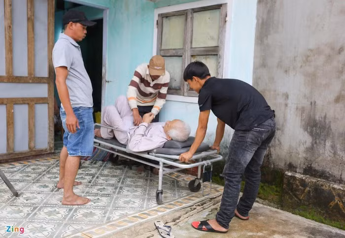 Người thân và lực lượng chức năng phải sử dụng xe để đưa cụ ông đi sơ tán tránh bão.