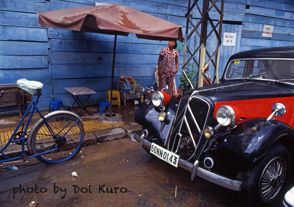 Quán này nằm ở một đoạn vỉa hè khá hẹp, bài trí đơn sơ với bàn xếp và ghế nhựa. Tương phản với quán là một chiếc Citroen Traction Avant bóng lộn choán ngay phía trước.