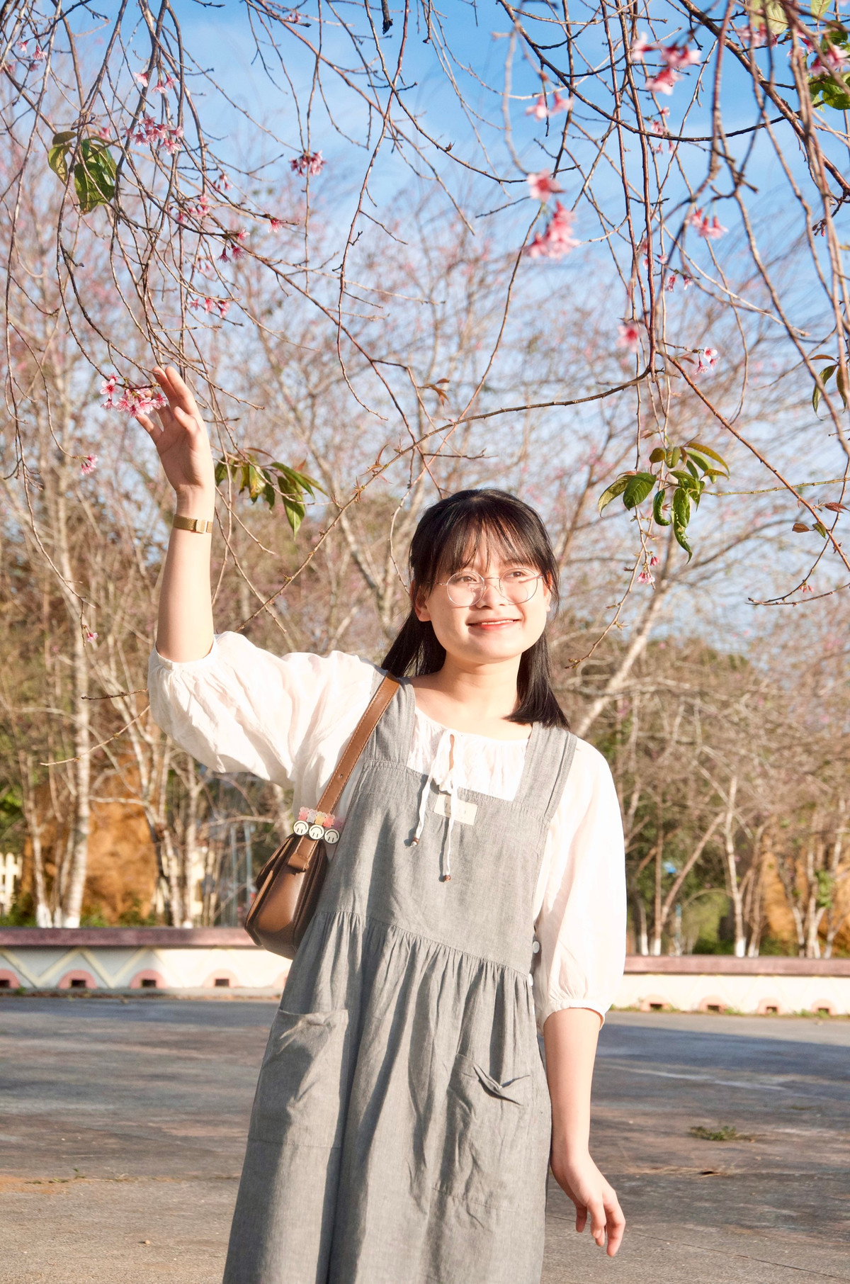 Bạn Mai Ly tranh thủ "săn ảnh" hoa đào tại Quảng trường thị trấn Măng Đen trước khi hoa tàn.