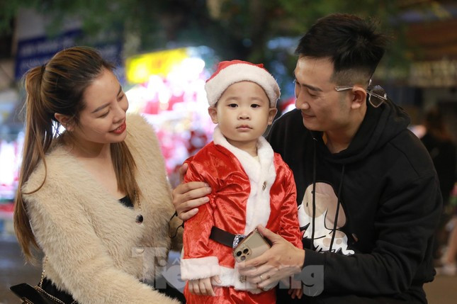 Gia đình trẻ cho con mặc trang phục ông già Noel xuống phố