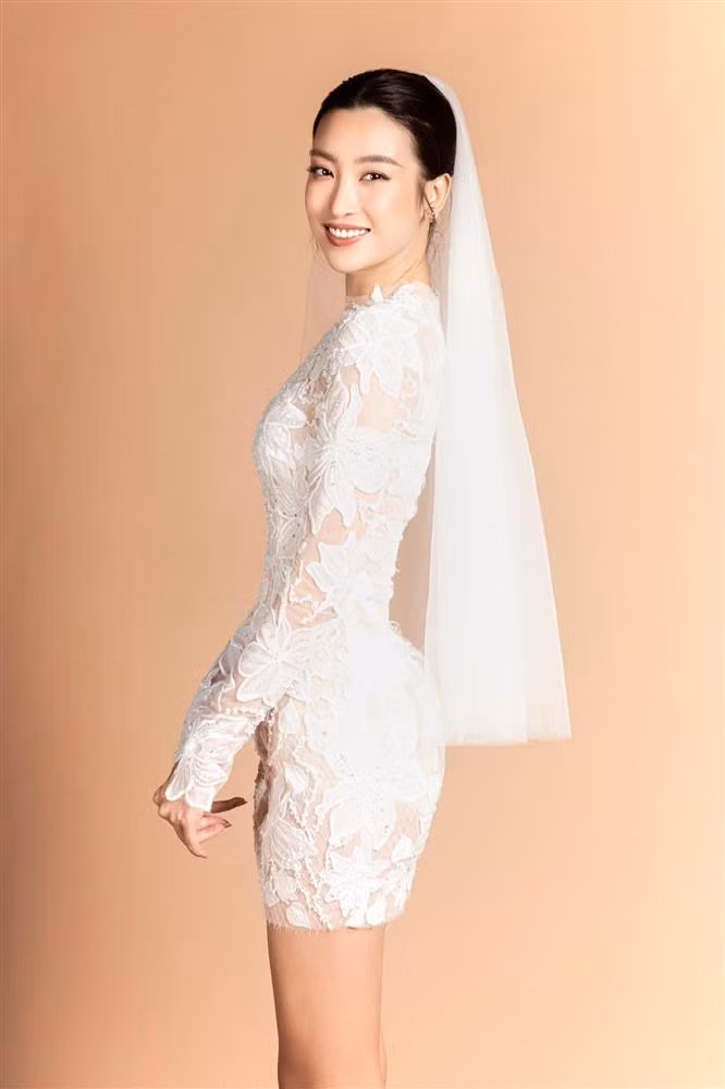Bộ váy là sự kết hợp tinh tế giữa những hoạ tiết hoa Carnation thủ công dệt trên nền chất vải ren thượng hạng dọc form đầm chuẩn mực mang lại nét cuốn hút và thơ mộng rất riêng cho người mặc. Theo chân xu hướng đồ cưới thế giới mùa FW22, thiết kế mang form dáng ballgrown không có tà dài thượt và mini/midi wedding dress được ứng dụng xuyên suốt, với điểm nhấn thời thượng từ voluminous ruffles.