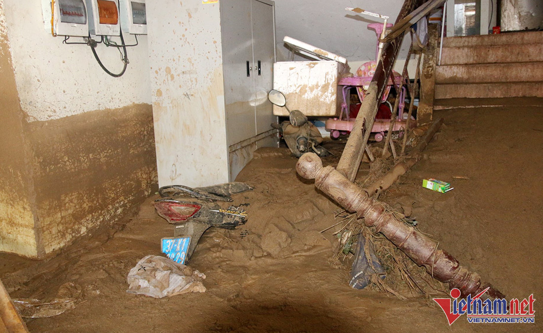 Chiếc xe máy và nhiều vật dụng chìm lấp trong bùn lầy. 