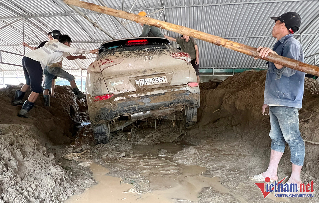 Đập tràn Hoà Sơn bắc qua khe Huồi Giảng nay đã hoàn toàn bị nhấn chìm. Để qua được bên kia khe, lực lượng chức năng đã phải bắc tạm cầu tre. Thiên tai xảy ra là điều không ai mong muốn, điều mà những người dân nơi đây mong mỏi nhất là nhanh chóng khắc phục hậu quả của cơn lũ để trở lại cuộc sống sinh hoạt thường ngày. (Ảnh: Ô tô đang được mọi người nỗ lực giải cứu ra khỏi đống bùn lầy) 