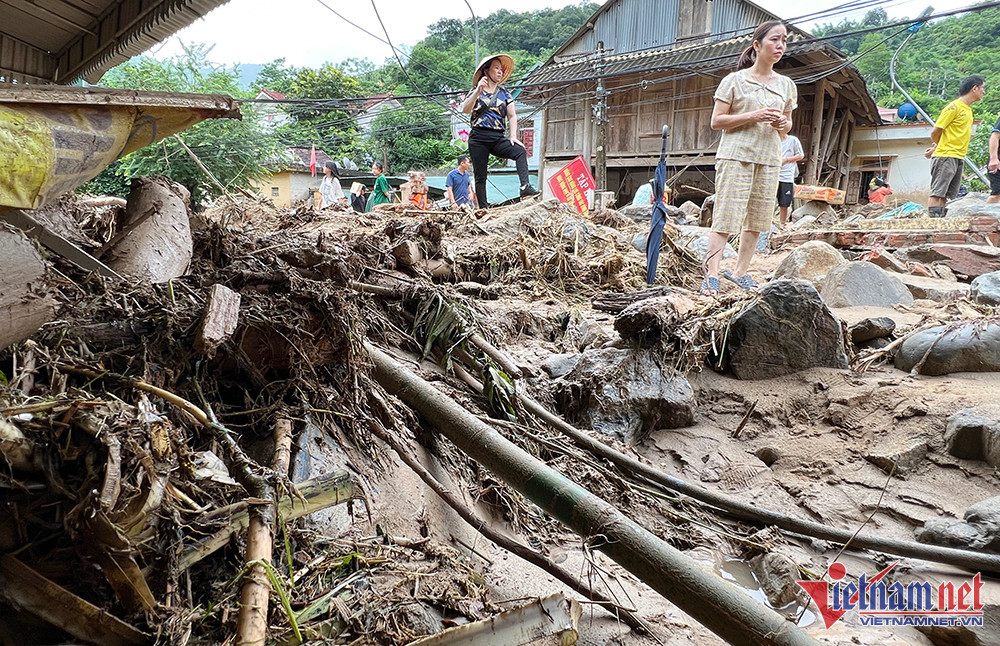 Vẫn chưa hết bàng hoàng, chị Nguyễn Thị Phong Lan (SN 1981) cho biết, lũ lên, gia đình đã chủ động đưa 2 xe máy lên gửi ở vị trí cao ráo, nhưng thật không ngờ, lũ về như thác, 2 chiếc xe máy gần 100 triệu đồng bị cuốn trôi, đến giờ vẫn chưa tìm thấy. (Ảnh: chị Hoa bàng hoàng trước ngôi nhà của mình lũ cuốn mất hút) 