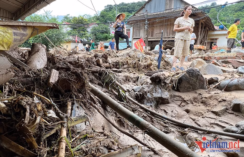 Vẫn chưa hết bàng hoàng, chị Nguyễn Thị Phong Lan (SN 1981) cho biết, lũ lên, gia đình đã chủ động đưa 2 xe máy lên gửi ở vị trí cao ráo, nhưng thật không ngờ, lũ về như thác, 2 chiếc xe máy gần 100 triệu đồng bị cuốn trôi, đến giờ vẫn chưa tìm thấy. (Ảnh: chị Hoa bàng hoàng trước ngôi nhà của mình lũ cuốn mất hút) 