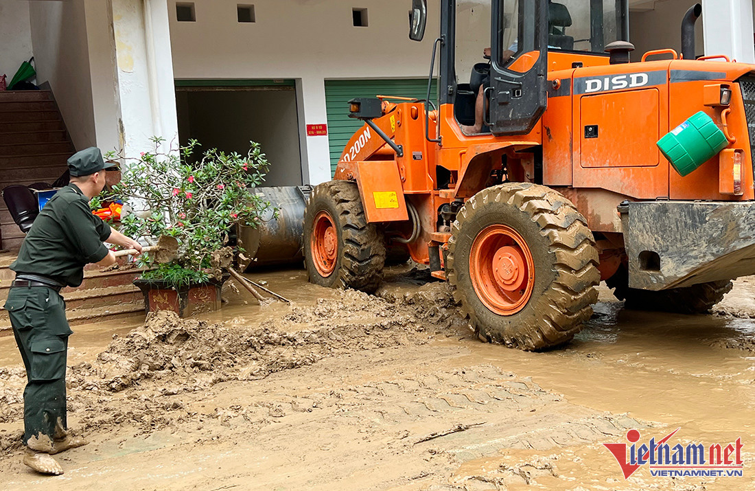Lực lượng Cảnh sát cơ động (Công an tỉnh Nghệ An) gồm 50 người đang cùng máy móc dọn dẹp bùn đất trong trụ sở UBND huyện Kỳ Sơn. 