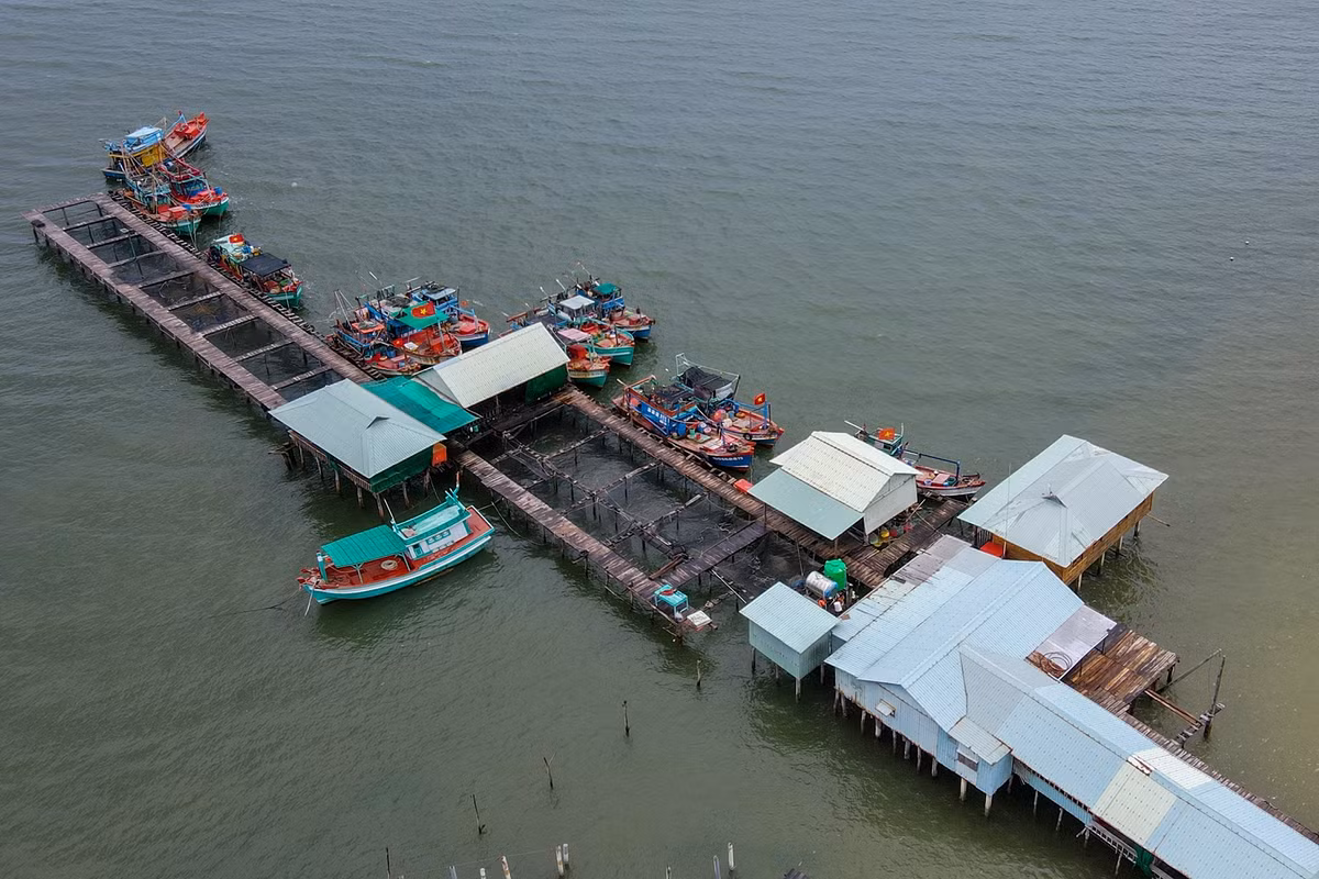 Một khu nuôi cá bè và nhà hàng xây dựng trái phép trên biển. Tại đây có khá nhiều tàu cá neo đậu.