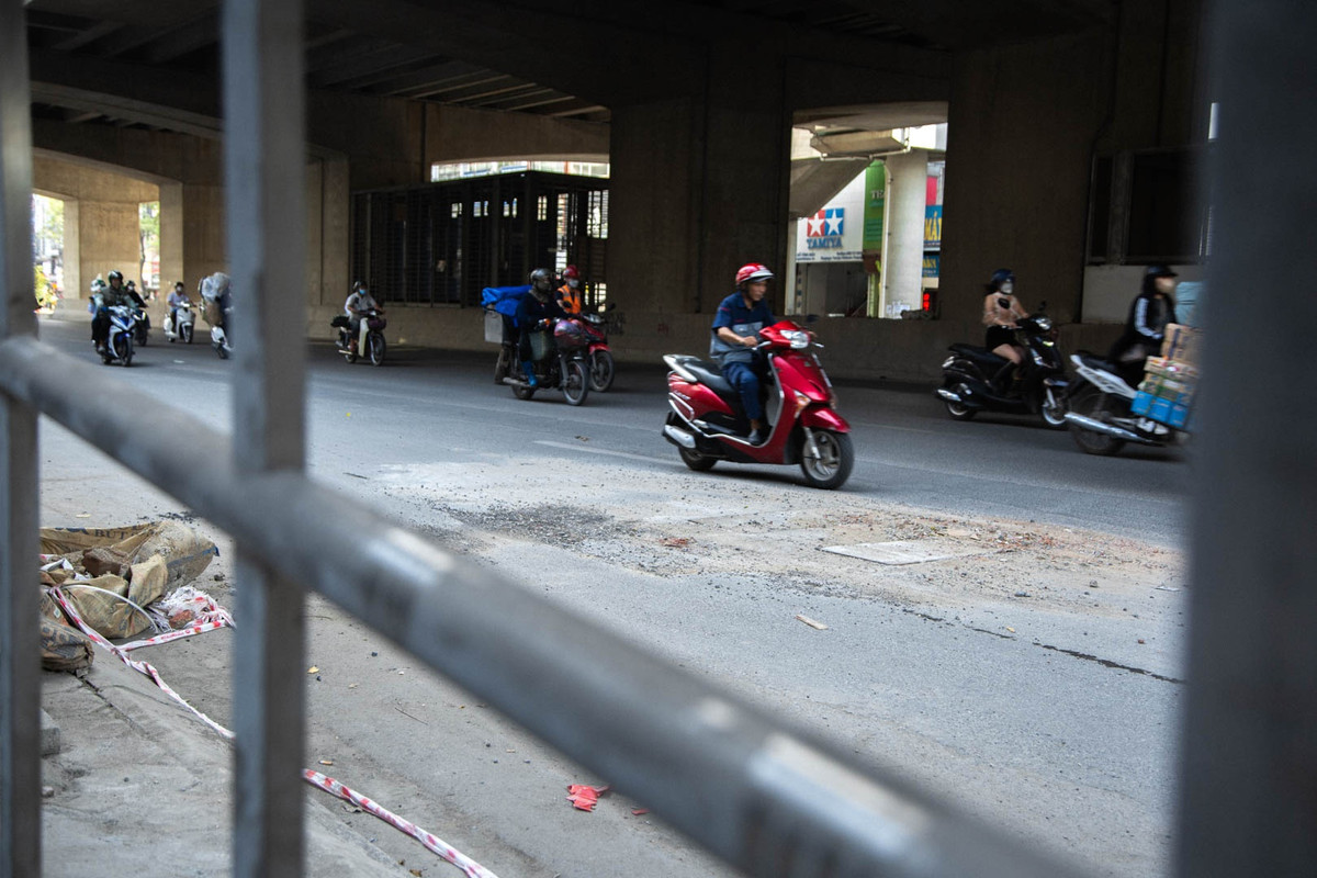 Rác thải, vật liệu xây dựng vứt bừa bãi hai bên mặt đường Hồ Tùng Mậu. Bên cạnh phần đường đã được trải nhựa để hoàn trả mặt bằng, vẫn có những chỗ bị cày xới để phục vụ thi công, ngổn ngang đá dăm, nắp hố ga nổi cao hơn mặt đường.