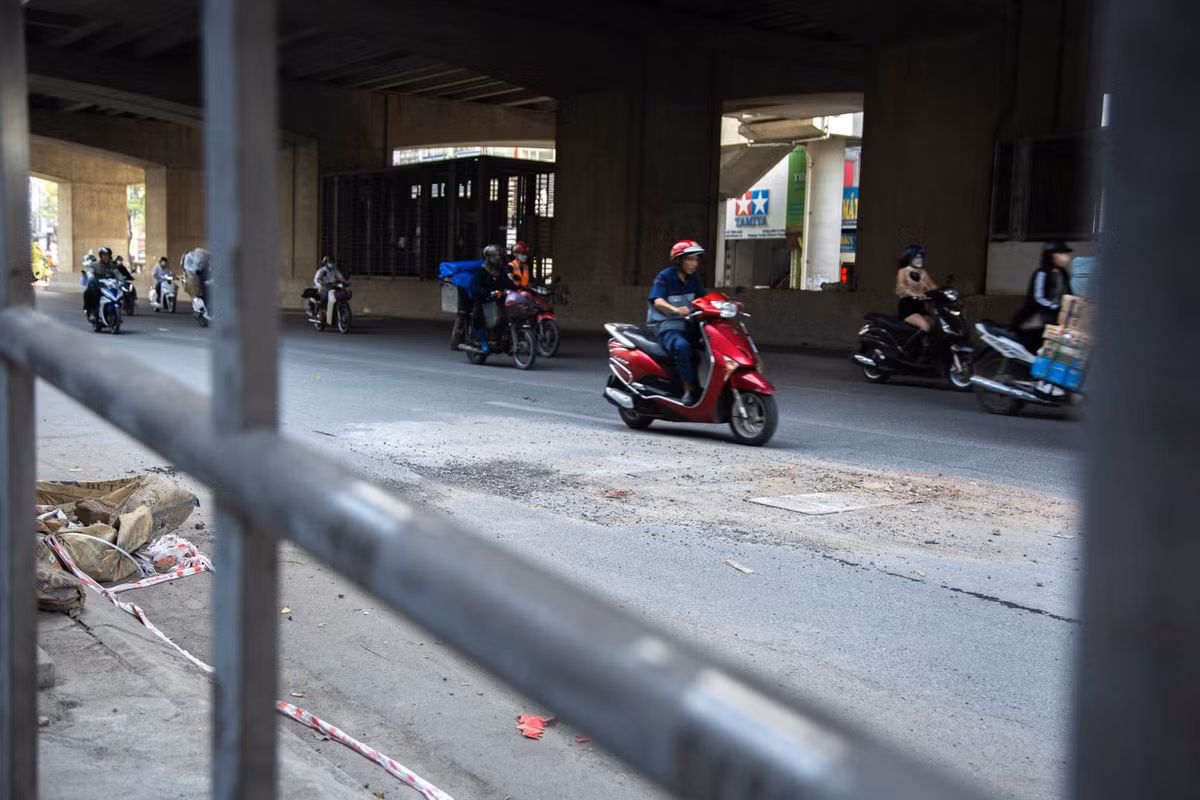 Rác thải, vật liệu xây dựng vứt bừa bãi hai bên mặt đường Hồ Tùng Mậu. Bên cạnh phần đường đã được trải nhựa để hoàn trả mặt bằng, vẫn có những chỗ bị cày xới để phục vụ thi công, ngổn ngang đá dăm, nắp hố ga nổi cao hơn mặt đường.