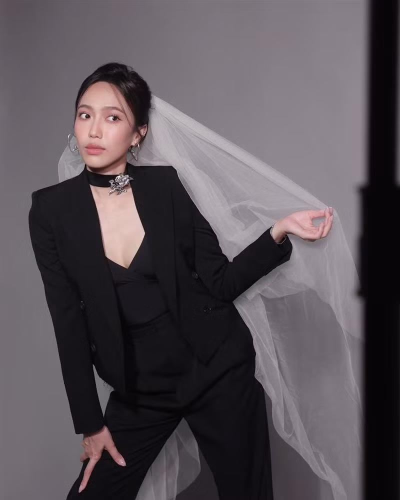 Điểm nhấn cho bộ suit này là chiếc áo 2 dây xẻ ngực khá sâu bên trong cùng chocker đính hoa hồng kim loại.