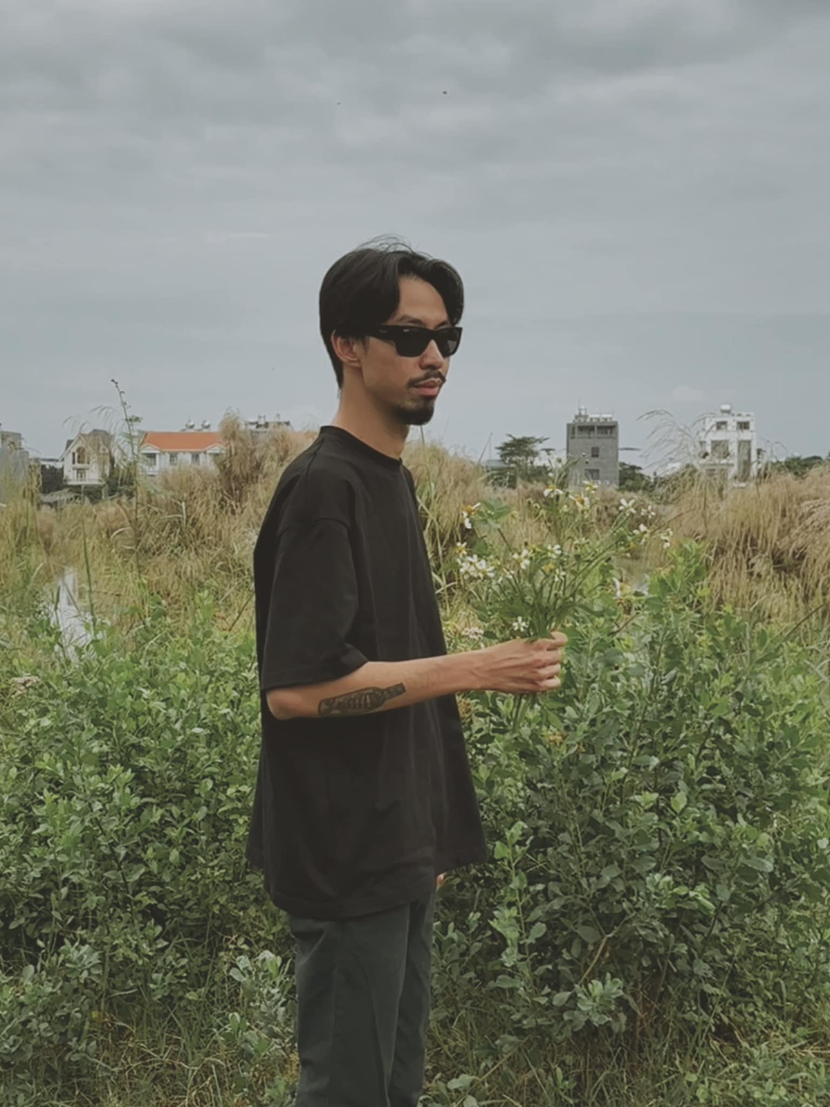 Rapper Đen Vâu hái hoa dại, nói vui là quà tặng fan nữ.