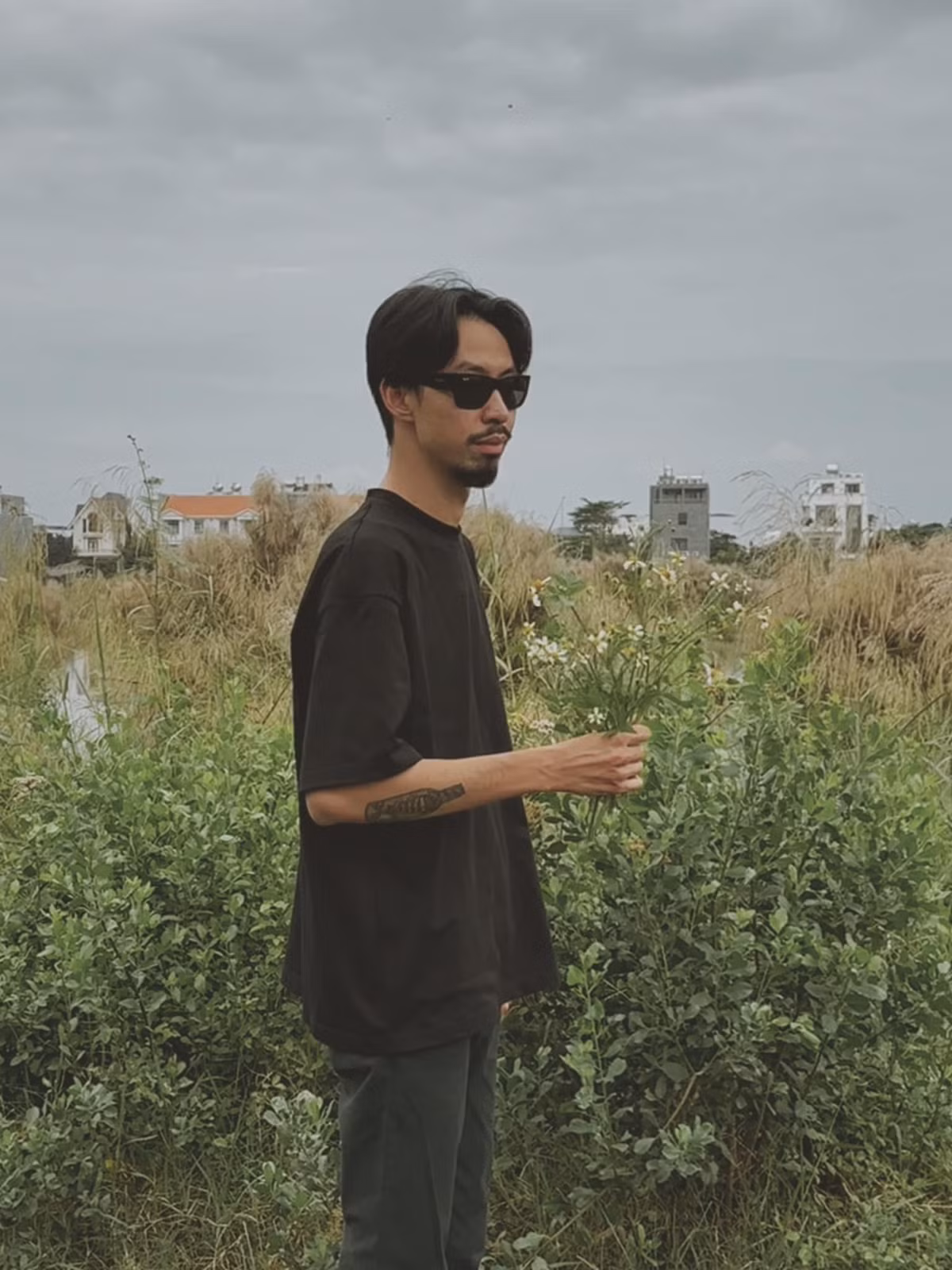 Rapper Đen Vâu hái hoa dại, nói vui là quà tặng fan nữ.