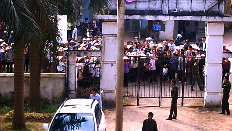 ... nhưng đợi lâu quá, họ đã tiến sát lại, dàn hàng trước cổng UBND xã. Lực lượng an ninh xã được điều động gác và đóng cửa không cho những người này theo bà Tranh vào bên trong UBND xã.