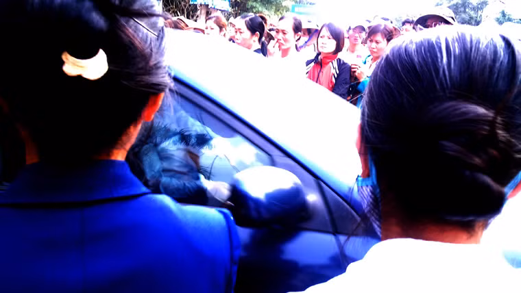 Khoảng 15h30 ngày 26/11, một xe của lãnh đạo huyện Tam Dương, Vĩnh Phúc rời khỏi UBND xã giữa dòng người chen chúc...