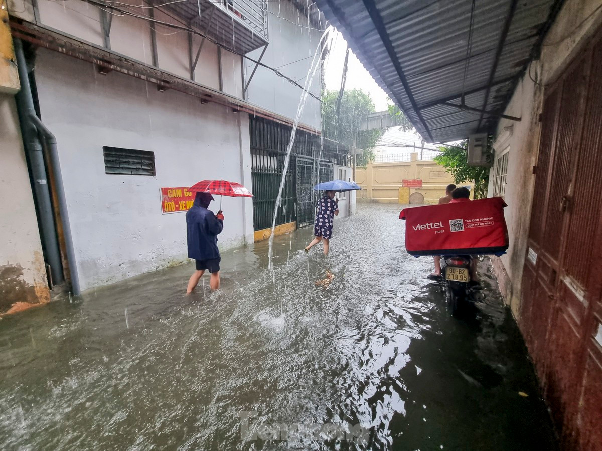 Người dân bì bõm lội nước, nhiều gia đình phải di chuyển xe máy đi gửi chỗ cao hơn.