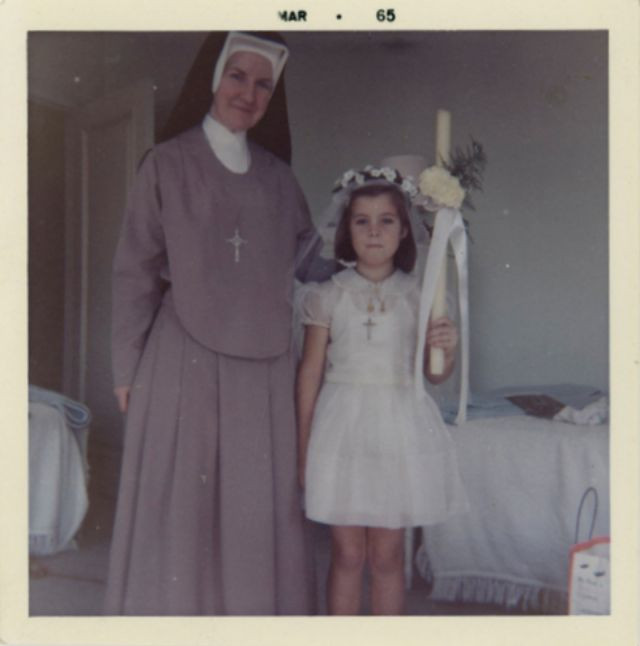 Caroline Kennedy đứng bên một bà sơ khi làm phù dâu tại một đám cưới ở nhà thờ, tháng 3/1965.