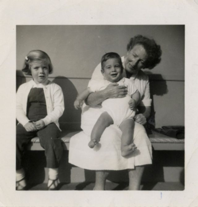 Bà bảo mẫu Maud Shaw nựng John F. Kennedy Jr. trong khi Caroline Kennedy ngồi bên cạnh.