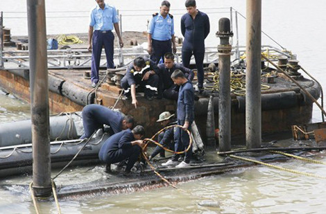 Thợ lặn Ấn Độ tiến hành bơm nước bên trong tàu để nâng con tàu lên khỏi mặt nước.