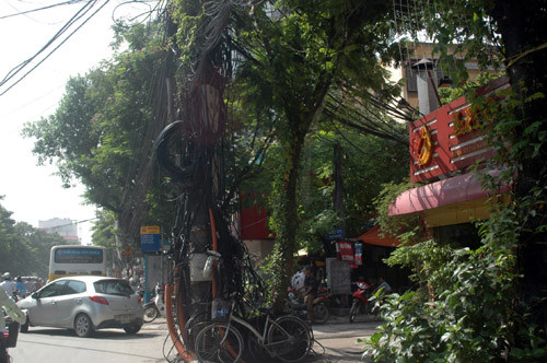 Cáp thông tin, dây điện kéo ngang, kéo dọc từ chân lên đỉnh cột điện trên phố Thái Hà, quận Đống Đa.