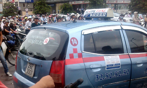 Chiếc xe taxi hất cảnh sát phường lên nắp ca pô.