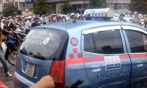 Chiếc xe taxi hất cảnh sát phường lên nắp ca pô.